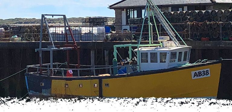 Main photo of a moored fishing boat and stacked lobster pots on Aberdyfi pier